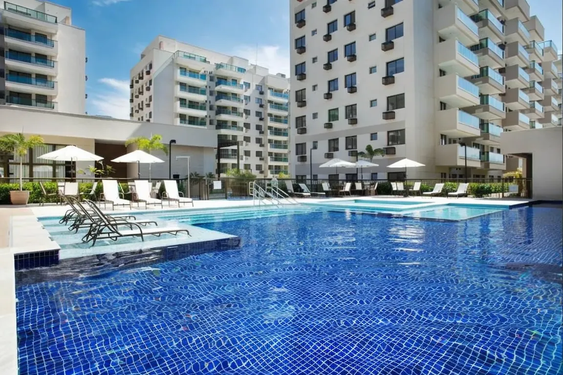 Vista da piscina adulta de 20 metros com deck molhado no condomínio Ocean Pontal Residence.
