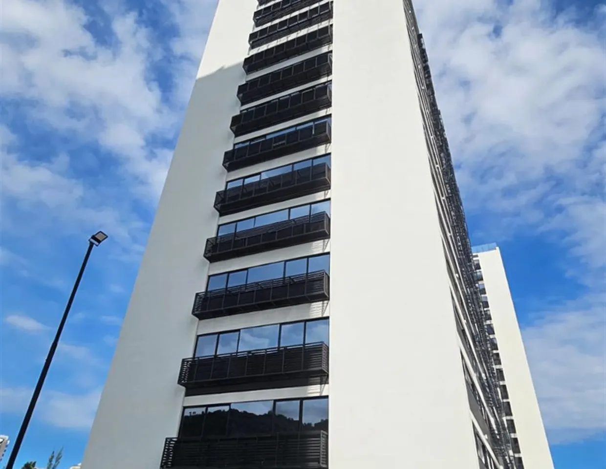 Vista aérea do condomínio: Visão panorâmica dos prédios do Etehe Residencial destacando a disposição das torres e áreas de lazer ao centro.