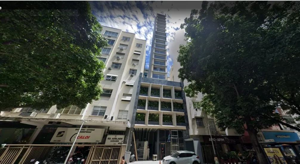 Vista de pedestre da charmosa Avenida Visconde de Pirajá, em Ipanema, com a entrada elegante do edifício ao fundo.