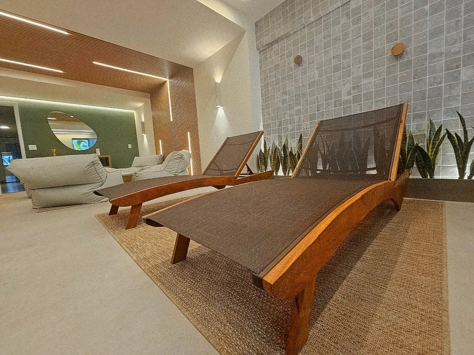 Varanda gourmet privativa de um apartamento tipo, equipada com guarda-corpo em vidro e espaço para convivência.