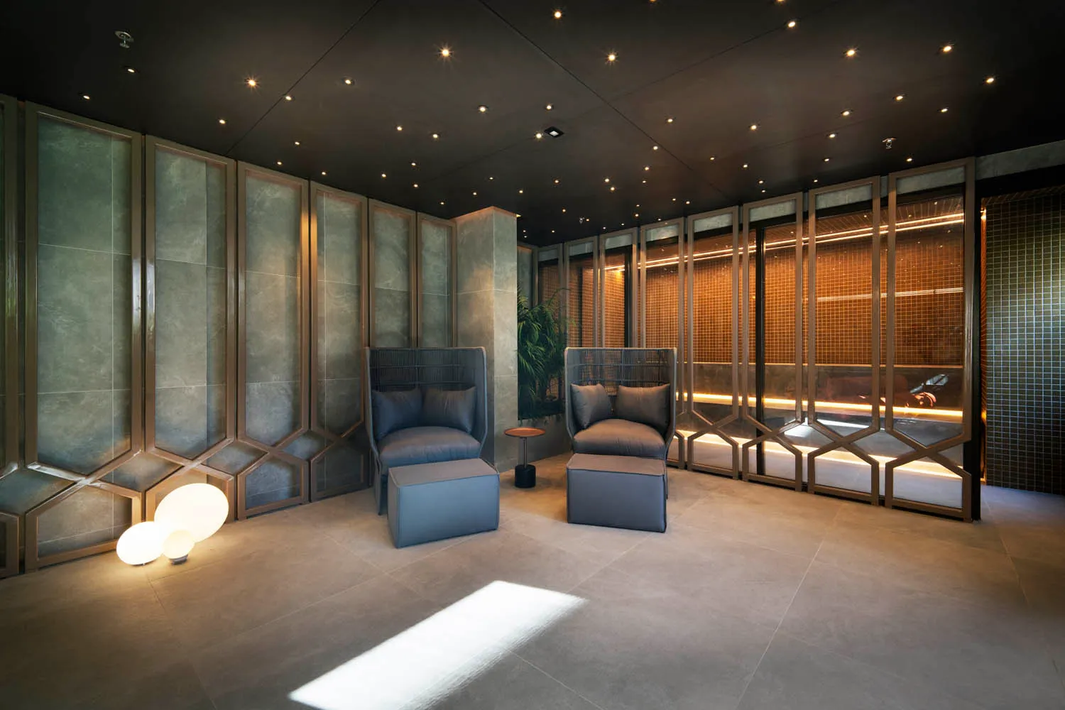 Sala de estar integrada com jantar no apartamento decorado do Iconyc by Yoo, com sofá cinza moderno, móveis planejados e iluminação embutida.